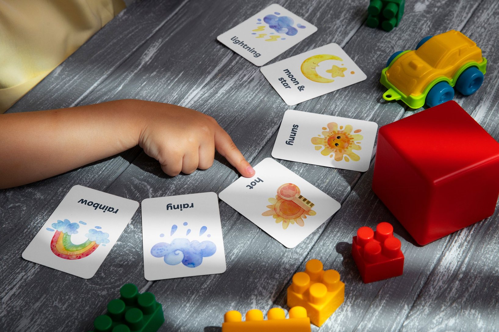 Un niño señalando tarjetas ilustradas durante una actividad de enseñanza en casa